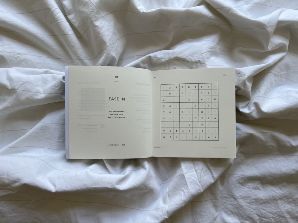 Open Nothing Urgent book showing the Ease In section and a Sudoku puzzle